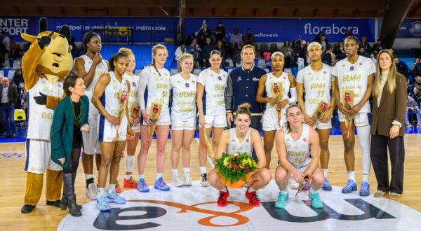 L'équipe des Gazelles du BLMA posent avec la mascotte Gazou sur leur parquet, bouquet de fleurs