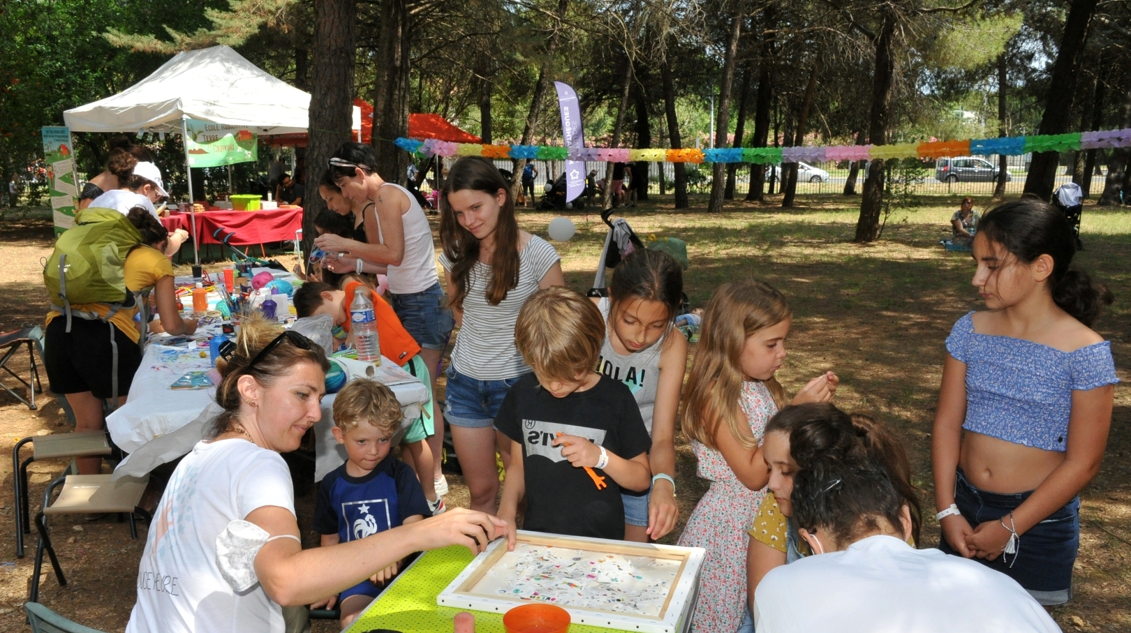 Enfants et adultes autour d'une table lors d'un atelier au festival Abracadabra, au Domaine d'O. 