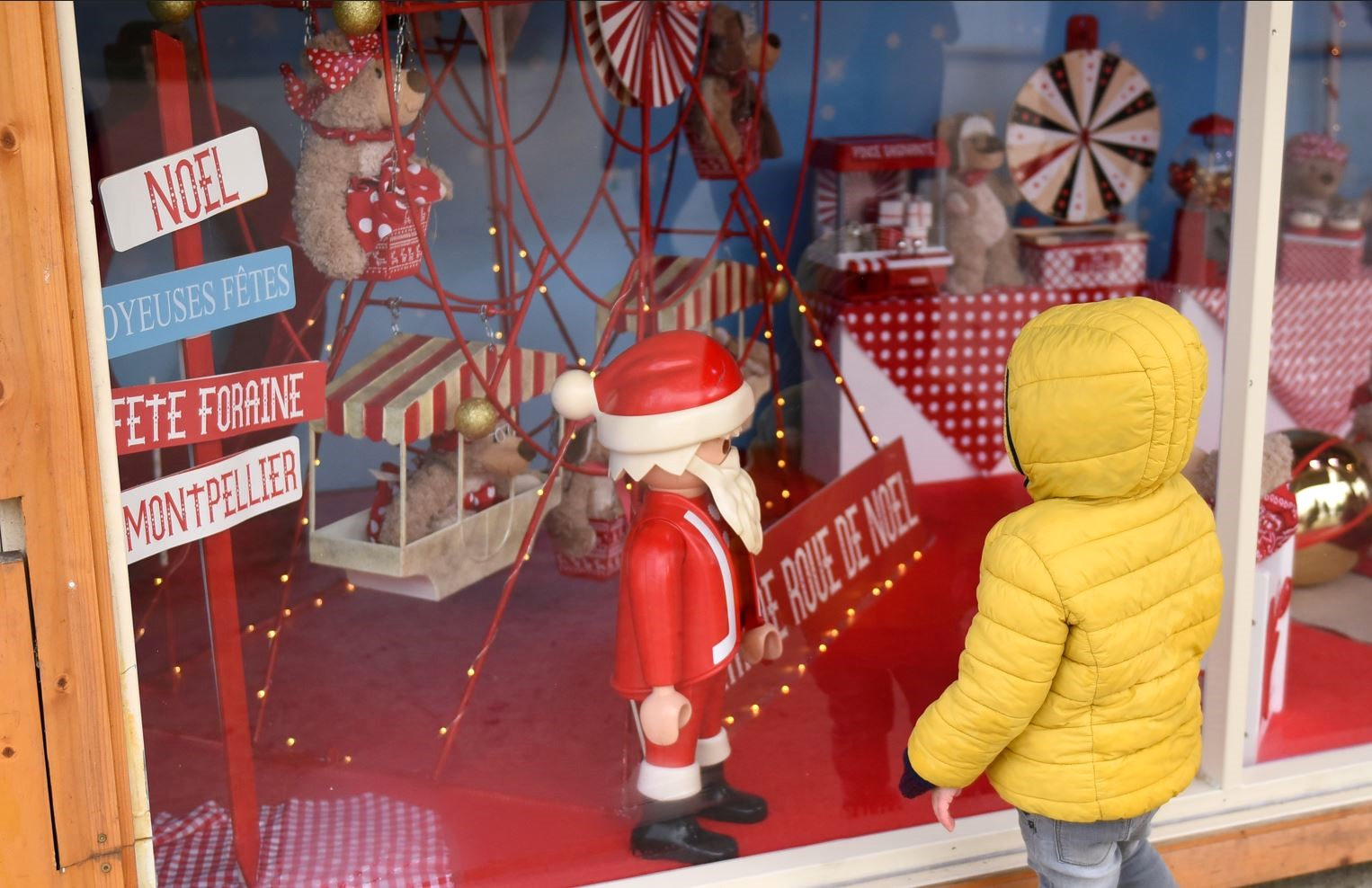 Enfant devant une vitrine avec un Père Noël