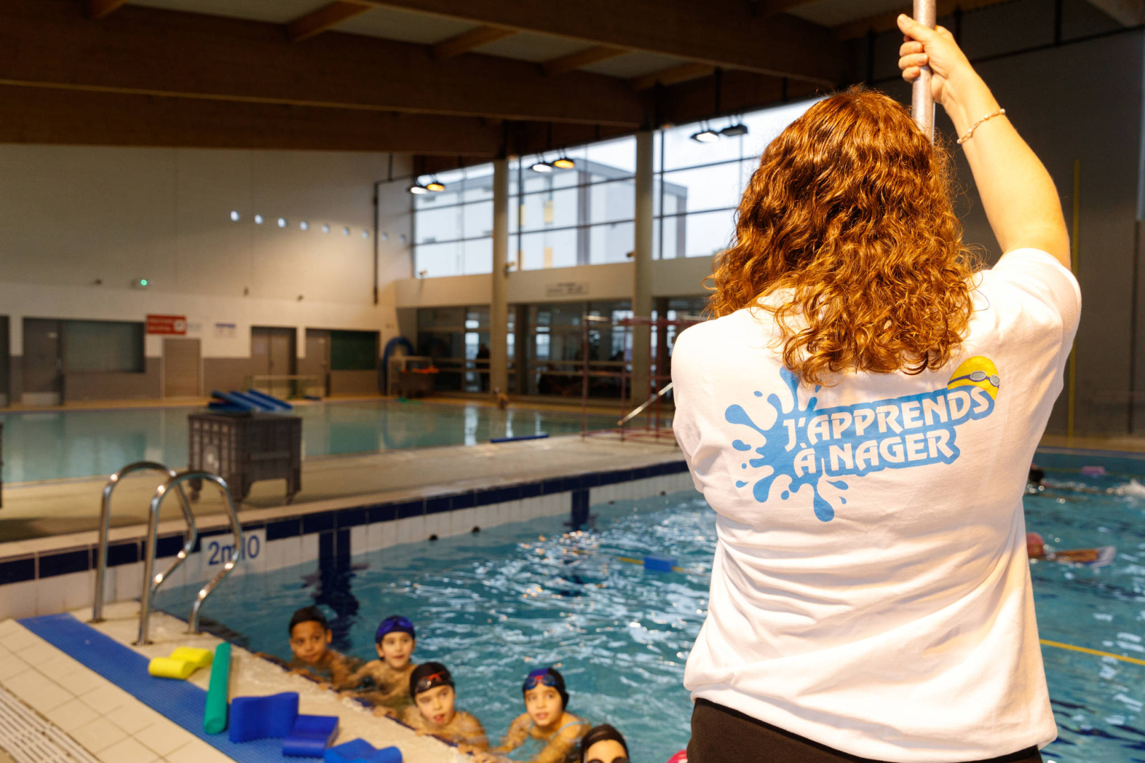 Maitre nageur et enfants dans la pisicne