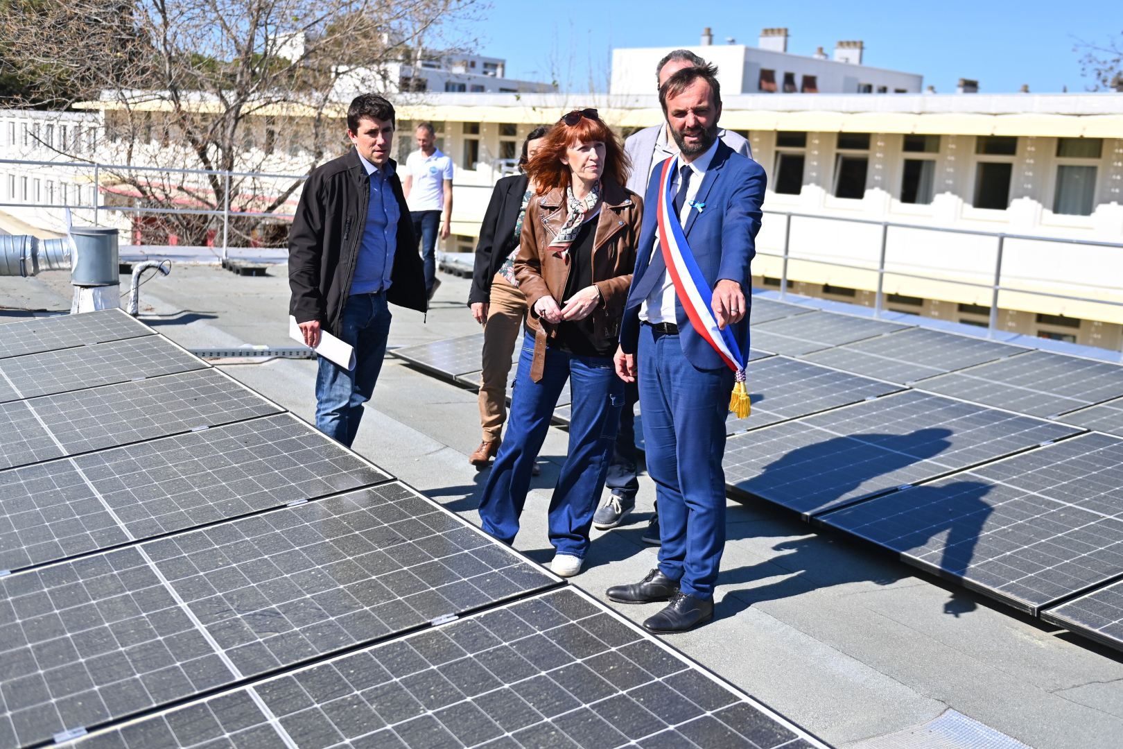 Des persones marchent sur le toit de l'école pour voir les panneaux solaires