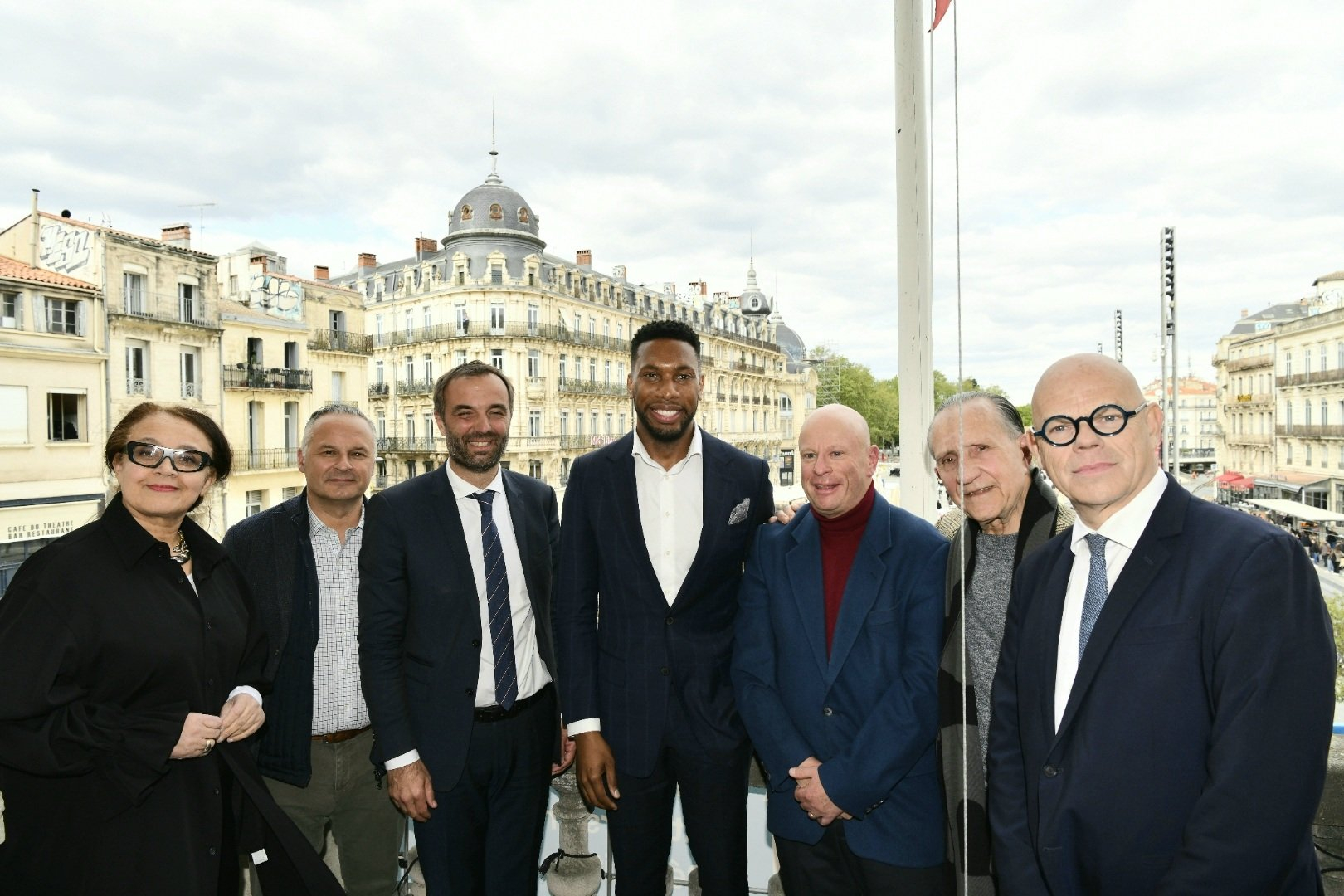 Roderick Cox sur le balcon de l'Opéra Comédie le jour de sa nomination entouré du président de la Métropole, Michaël Delafosse