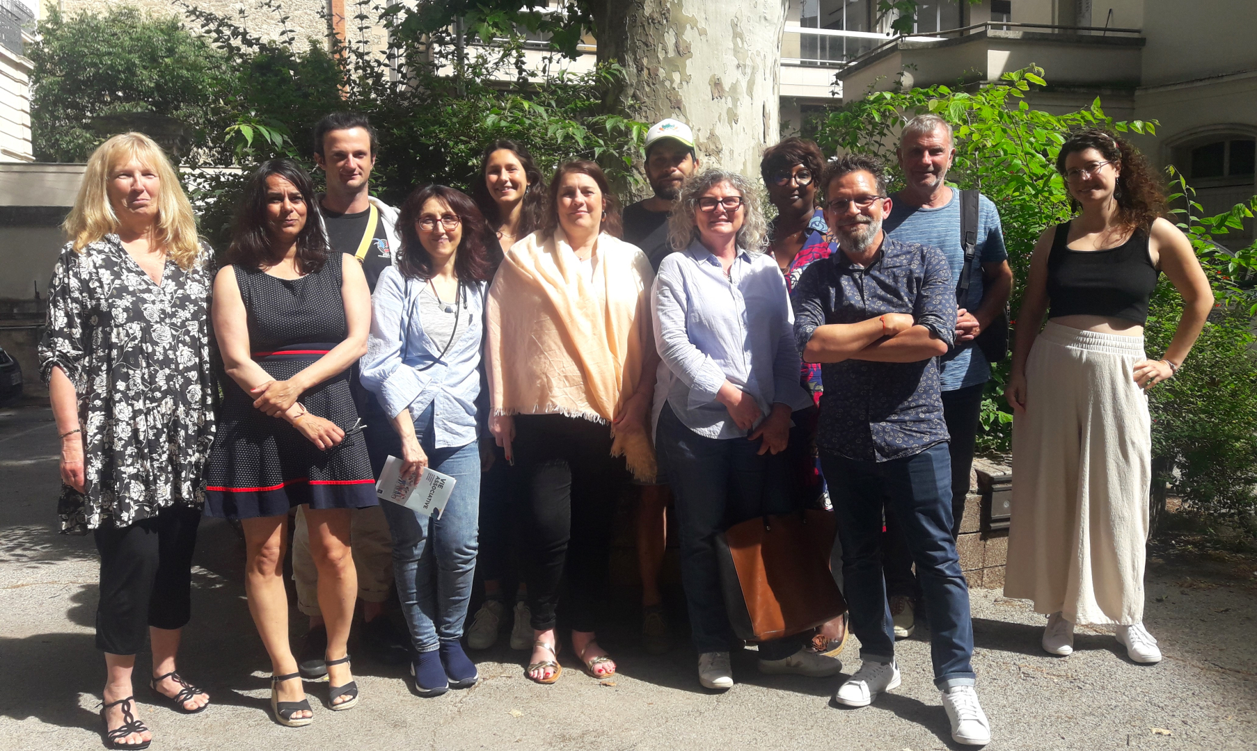 Photo de groupe dans la cour de la Maison de la Démocratie