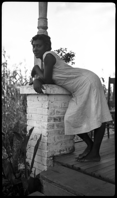 Femme debout, appuyée sur la colonne d'un porche
