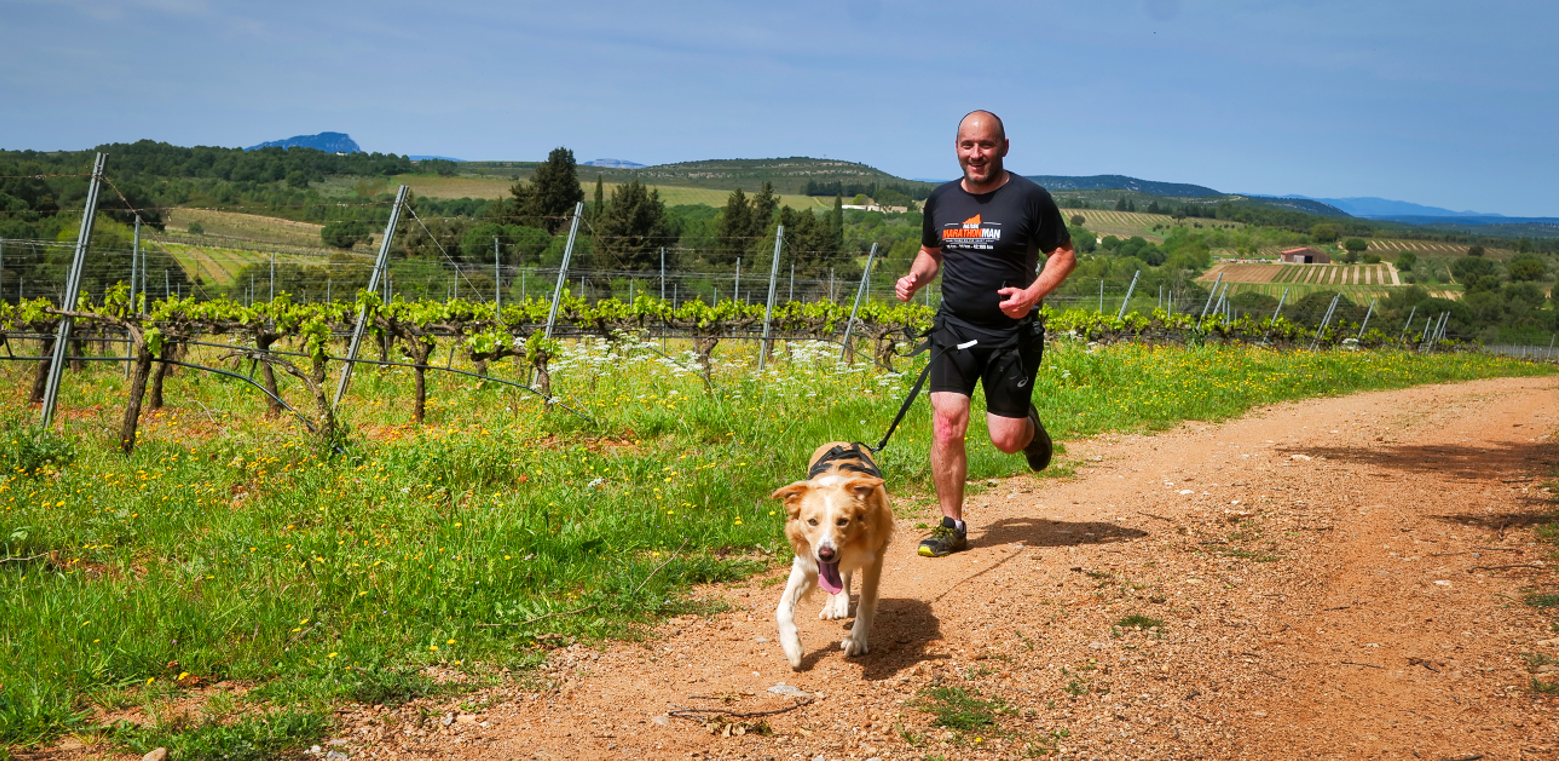 Un homme court avec son chien