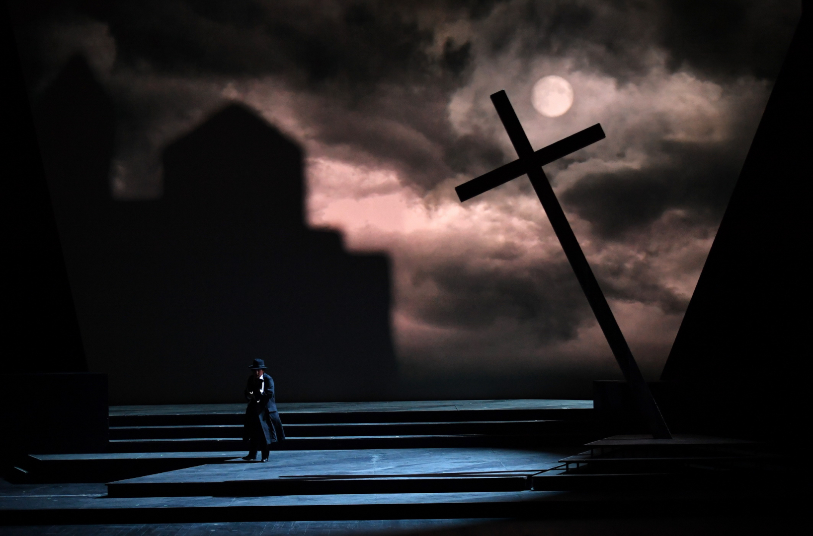 Un décor au clair de lune, avec une croix penchée sur la scène