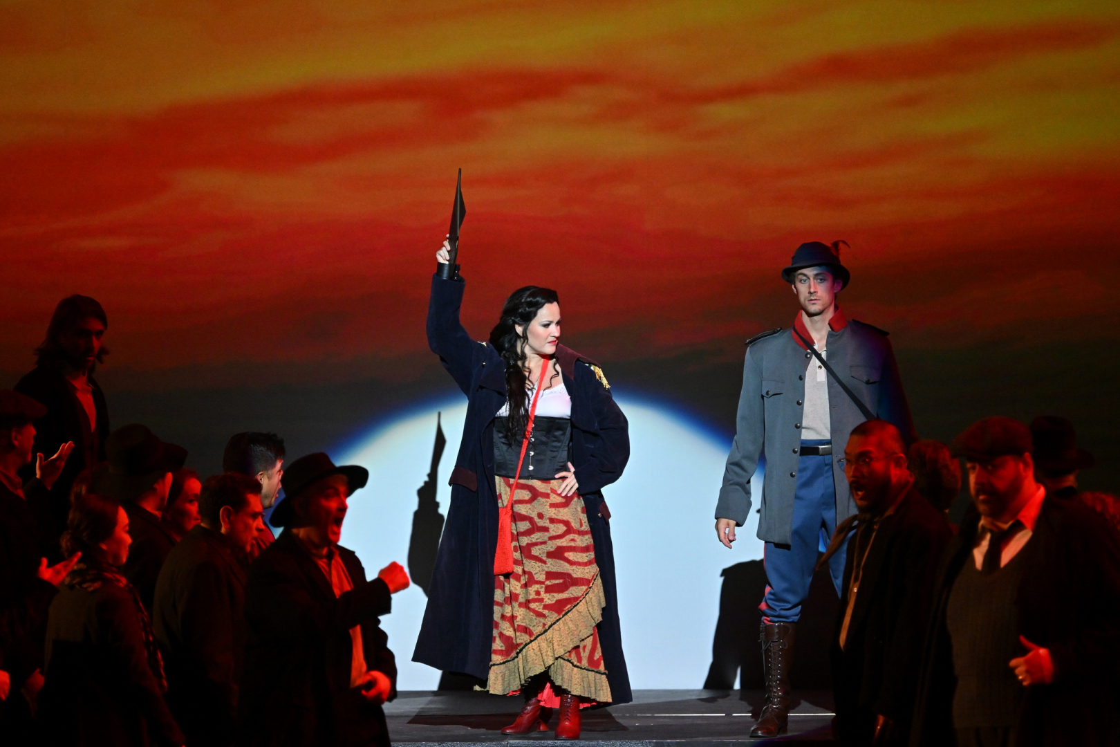 Une chanteuse en costume andalou au milieu d'un groupe, elle tient un éventail