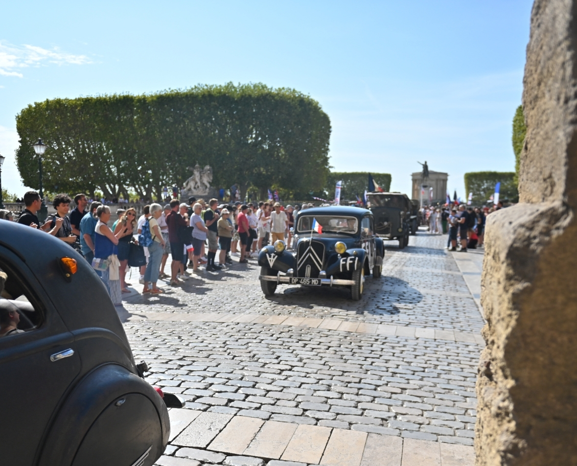 Véhicule d'époque aux couleurs des FFI sous l'Arc de Triomphe 