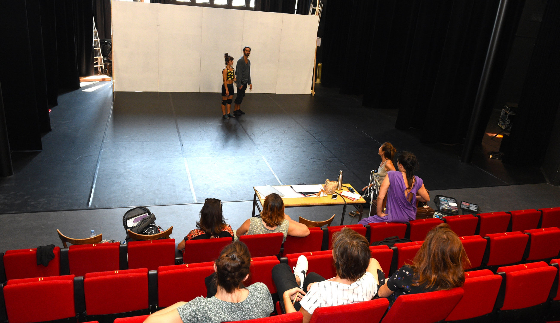 Photo de résidence de création dans un théâtre, avec équipe sur la scène et dans la salle