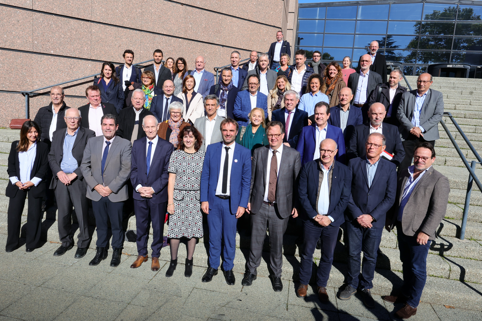 Photo de famille des membres de l'Agence de développement et des transitions sur les marches du Corum 