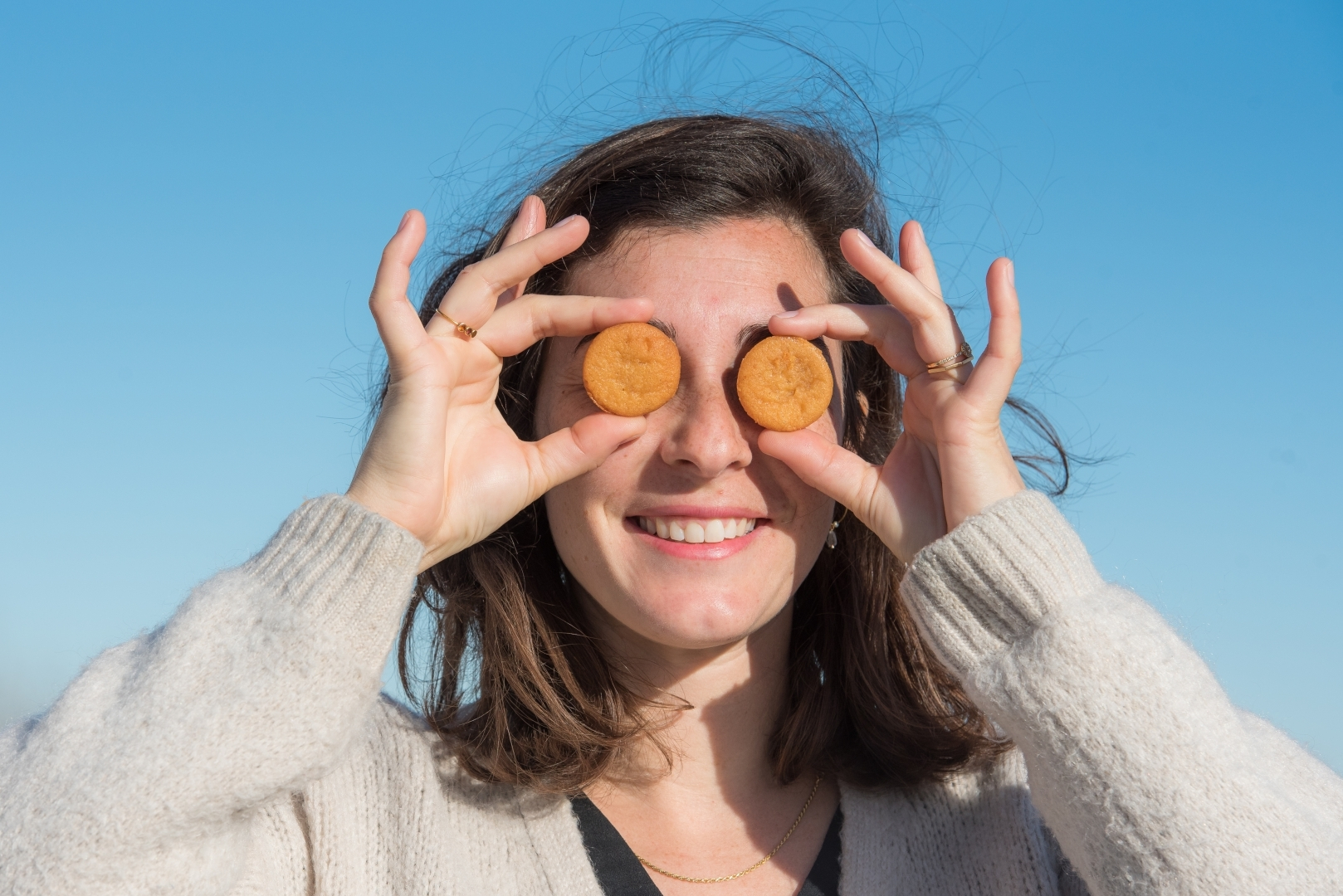 Photo avec femme qui met des gâteaux à la place des yeux pour mettre le produit en valeur 