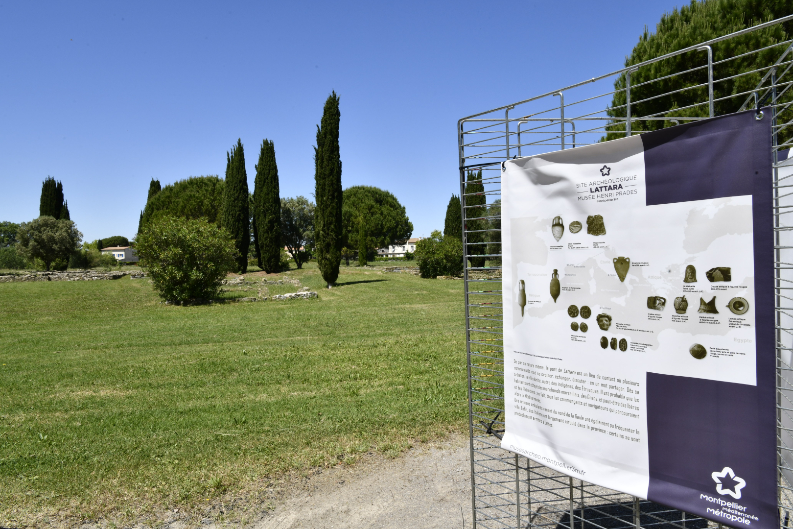 site archéologique extérieur avec vestiges arbres et panneau de présentation 