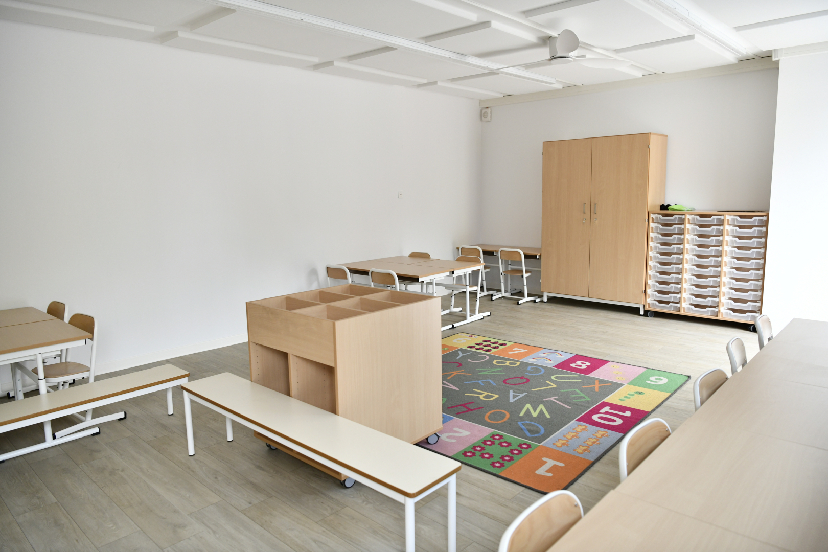 salle de classe rénovée chaises tables armoire rangements sol décoré