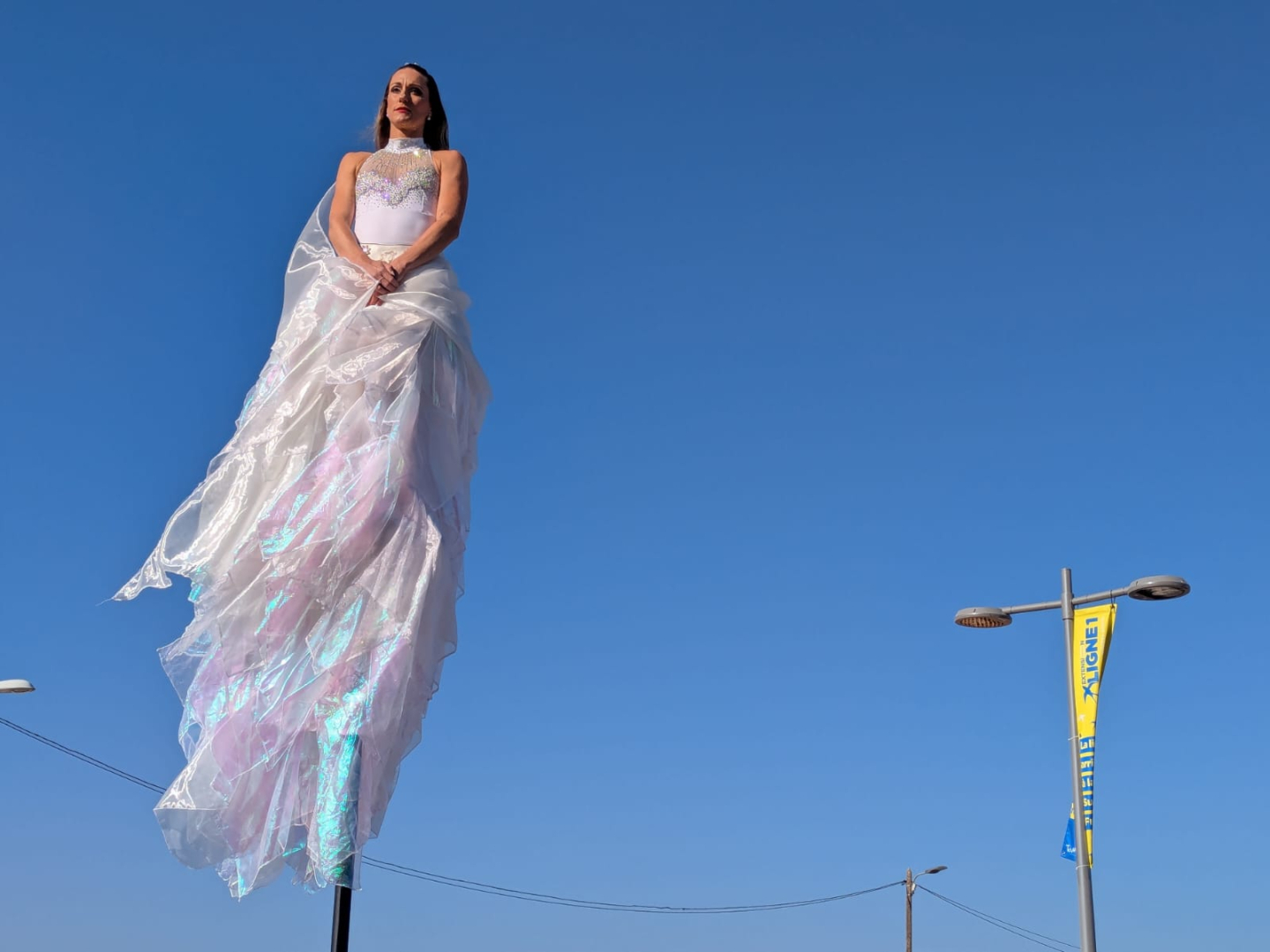 danseuse "ange" dans les airs avec une banderole "Ligne 1e en arrière plan, ciel