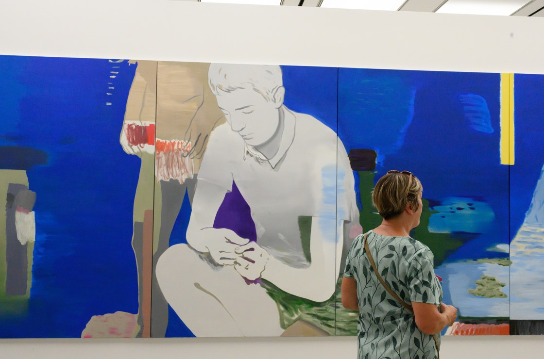 Visiteur devant une toile bleue