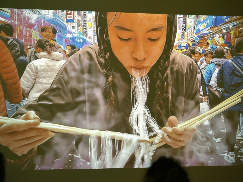 vidéo murale, une femme mange du plastique avec des baguettes