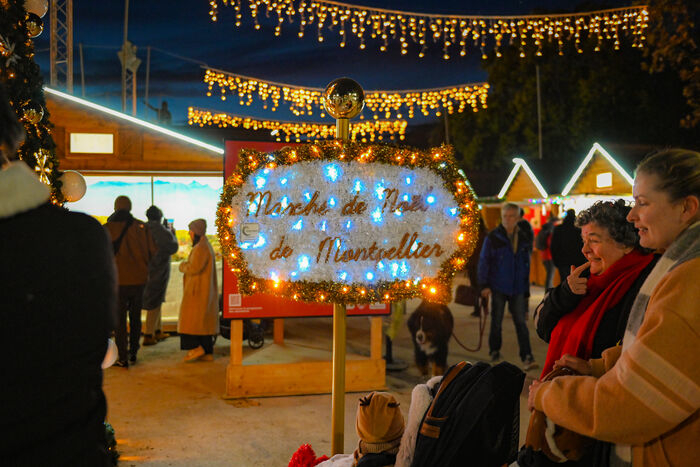 illuminations et décoration de Noël, crèche sous vitrine, chalets, personnes souriantes, chien