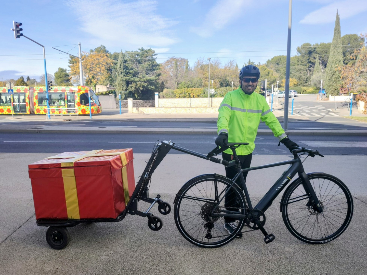 Deniz Ince avec son vélo-remorque décoré en paquet cadeau pour la période des fêtes