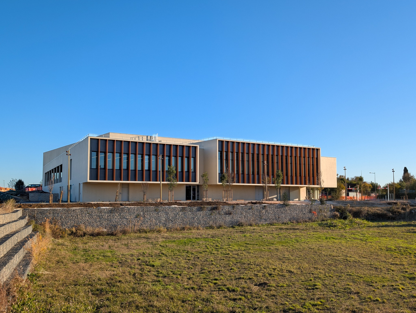 Palais des sports de Boirargues à Lattes, bassin de rétention au premier plan, ciel bleu 