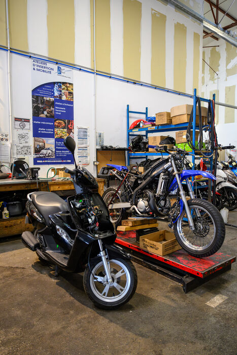 v&eacute;hicules deux roues dans l'atelier du garage solidaire &eacute;tag&egrave;res outils affiches