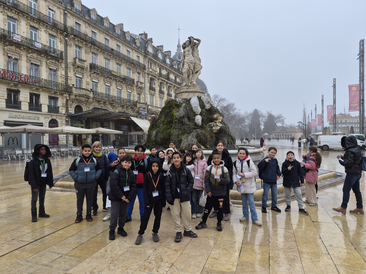 place de la Comédie, groupe d'écoliers, enseignants, fontaine des Trois Grâces, bâtiments, ciel gris