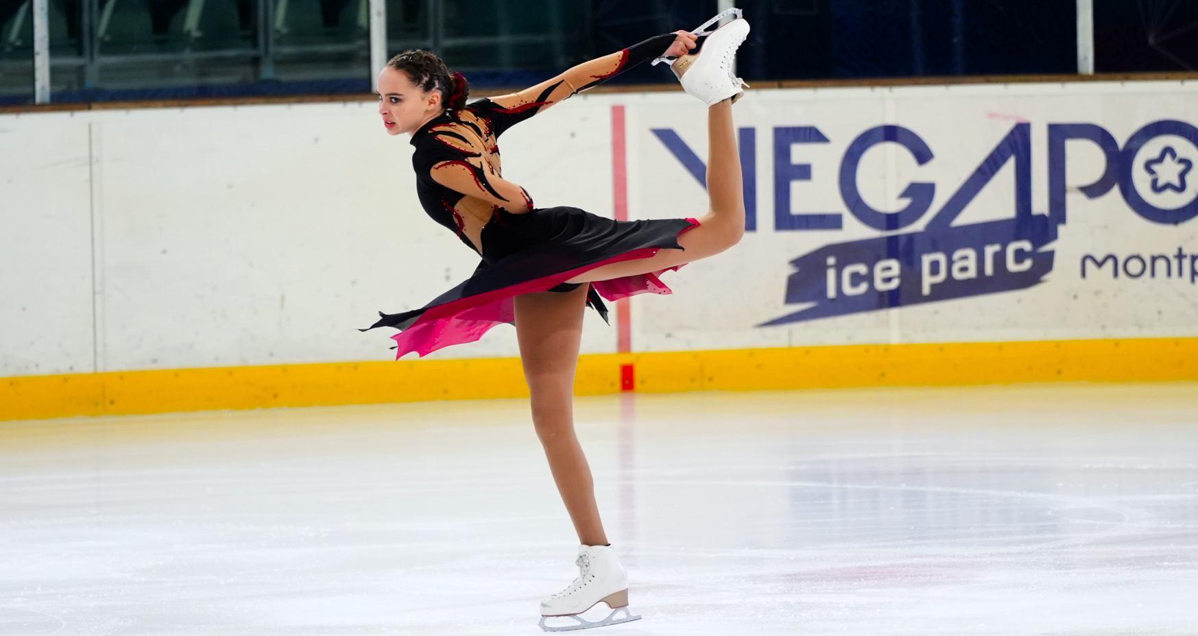 Photo de patineuse faisant une arabesque au trophé du soleil