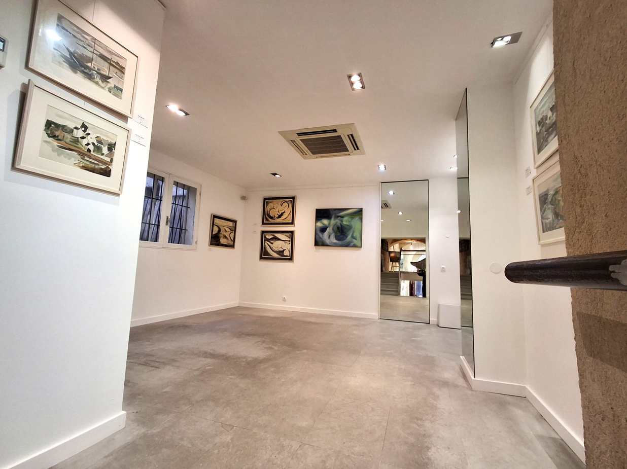 premier étage de la galerie avec tableaux aux murs