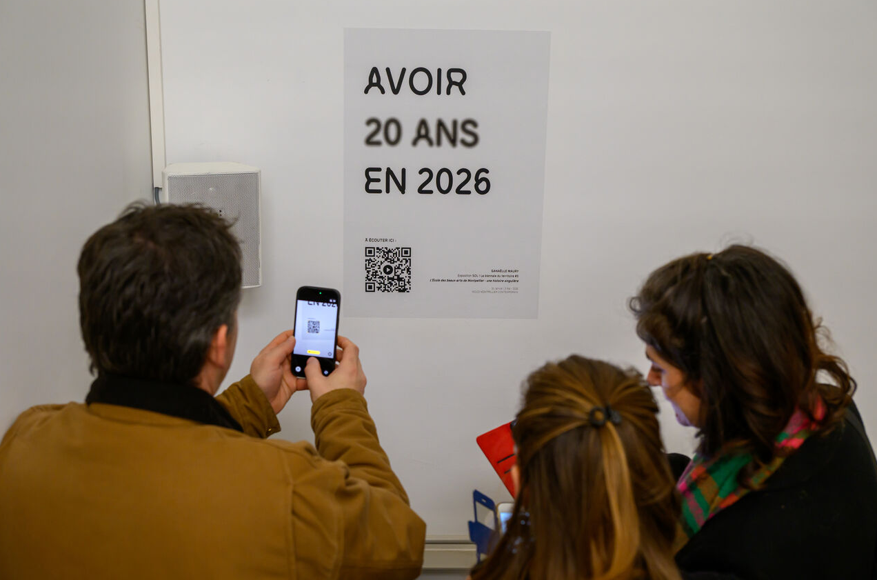 Des visiteurs photographient l'affiche "avoir 20 ans en 2026"