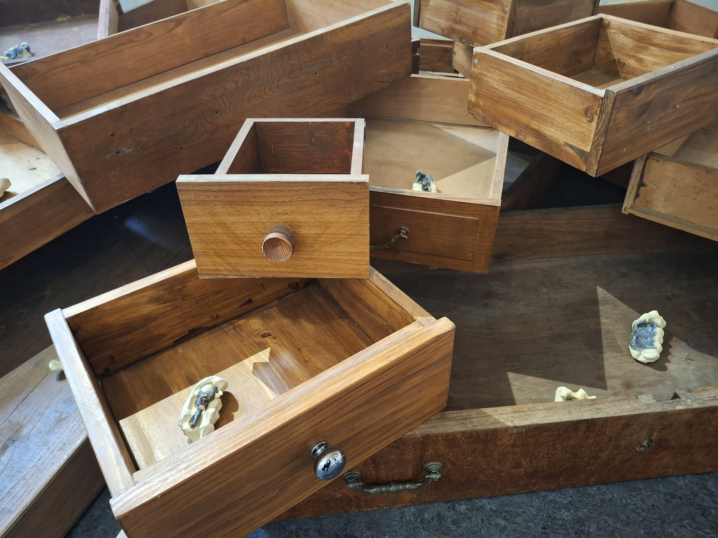 Installation de tiroirs en bois avec à l'intérieur les moulages d'empreinte de mains retenant une clé