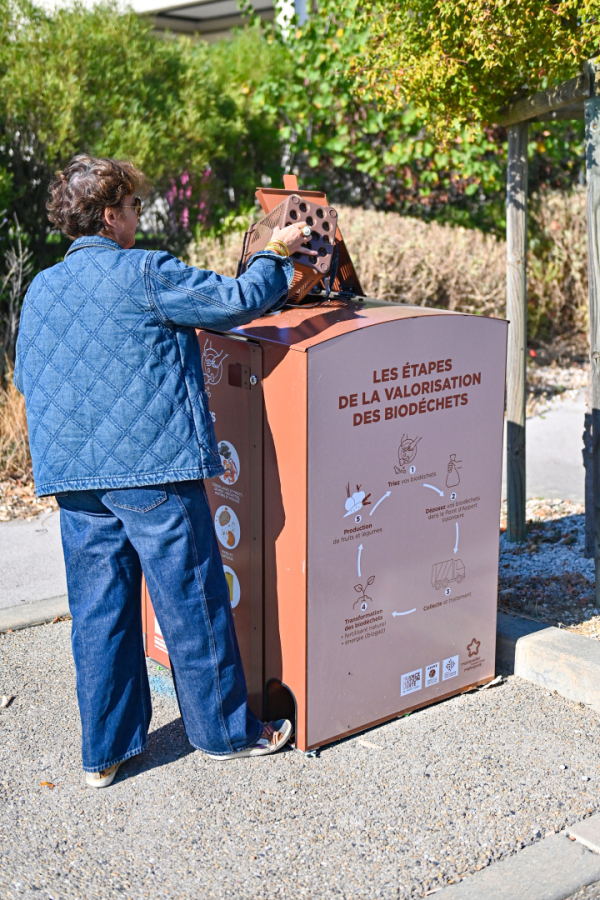Personne vide biodéchets dans borne