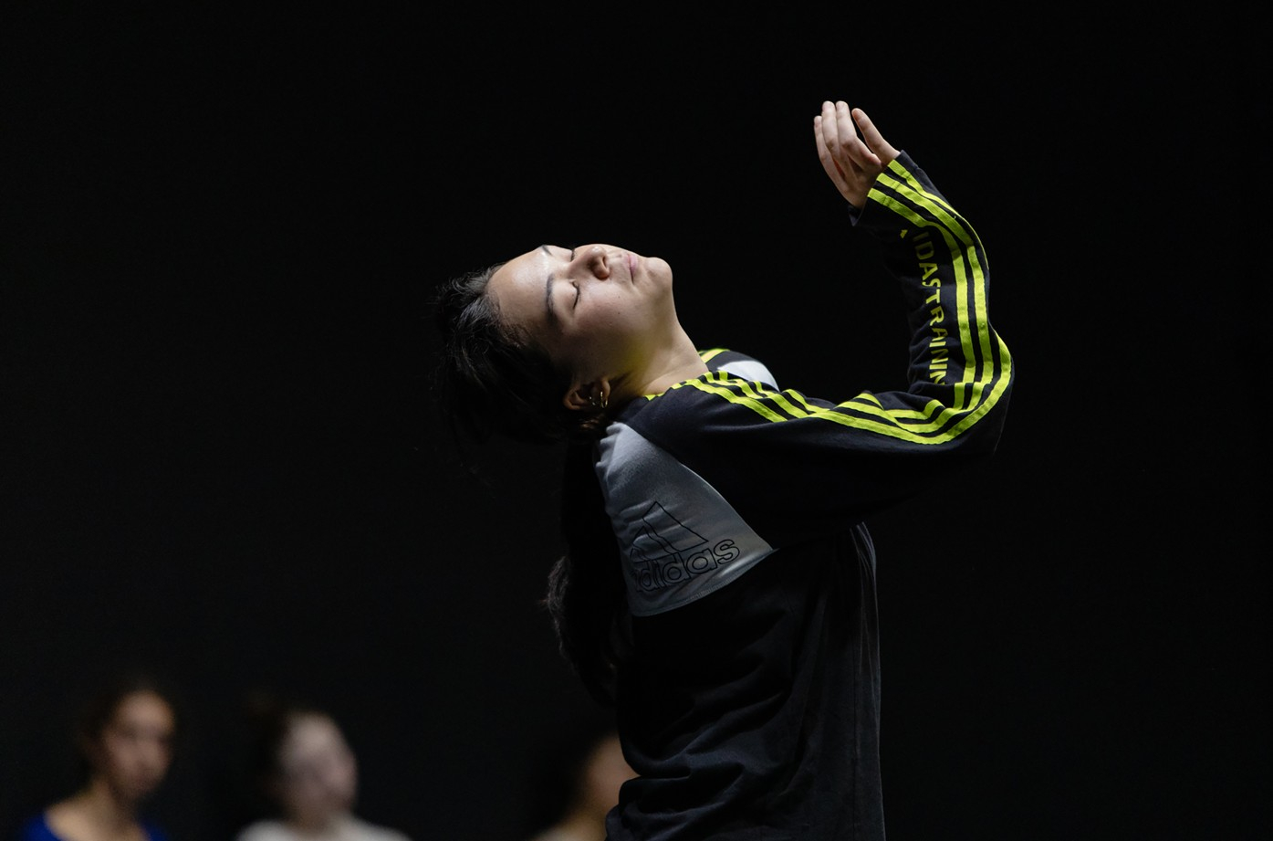 Une danseuse en survêtement, cambrée en arrière