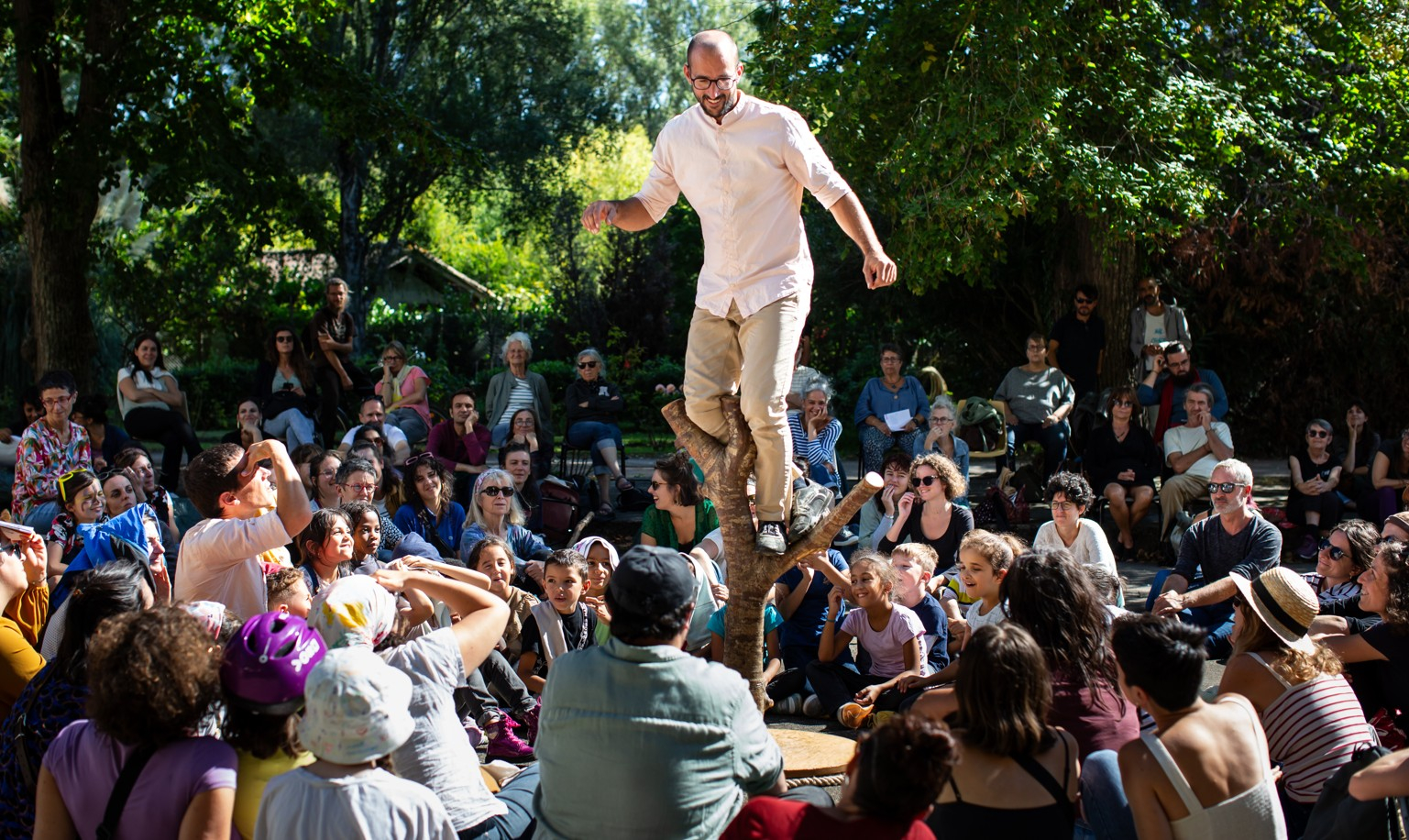 Un artiste du spectacle Pour Hêtre, en équilibre sur un tronc d'arbre