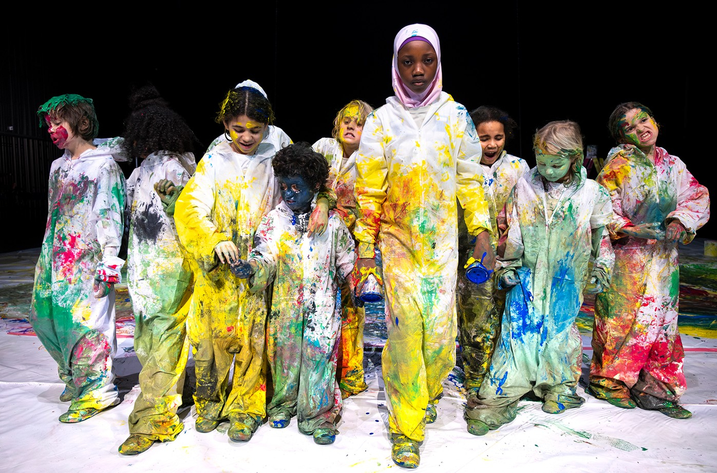 Photo de jeunes enfants en tenue, recouverts de peinture