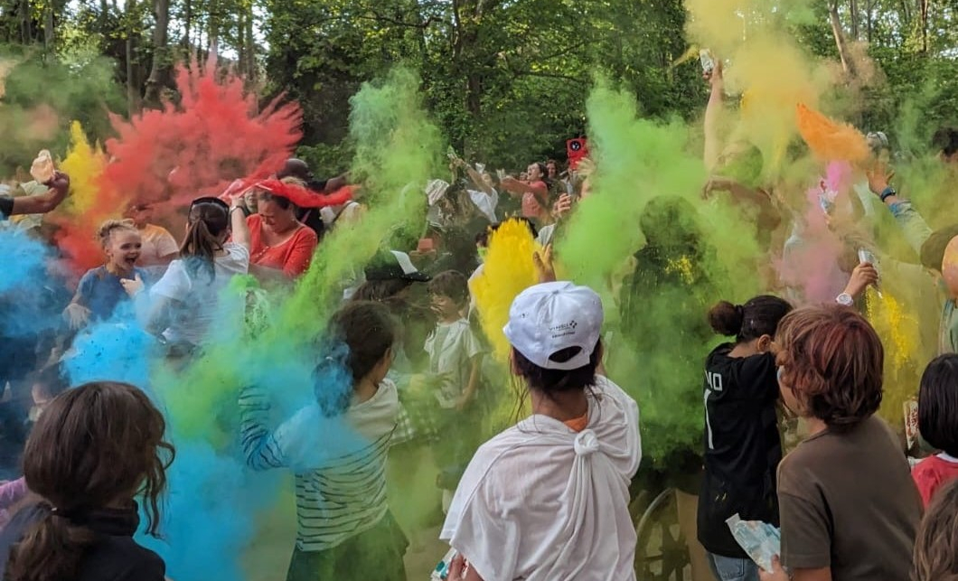 les participants jètent des poudres colorées dans l'air 