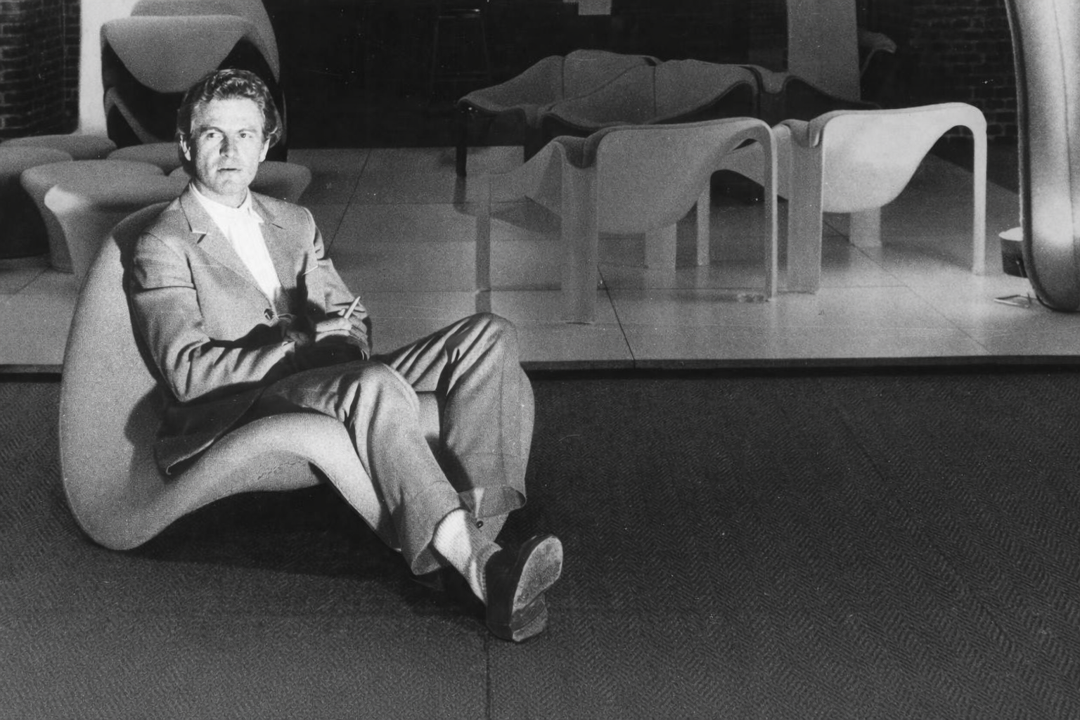 Pierre Paulin assis sur un de ses fauteuils
