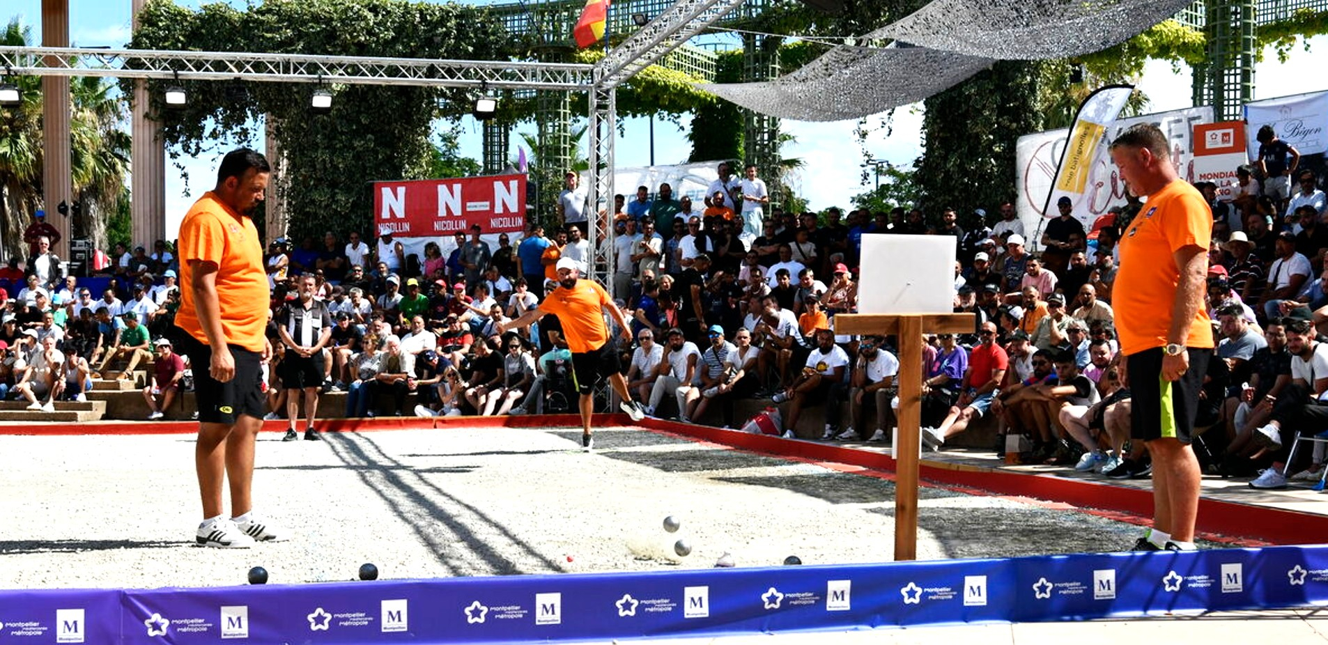 Joueurs de pétanque en tshirt orange sur terrain