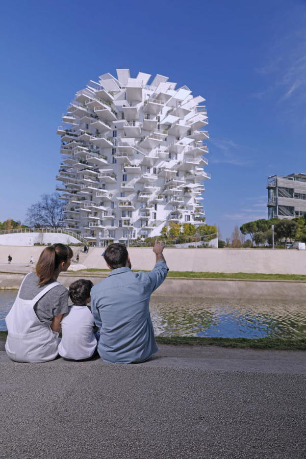 Photo d'un couple assis devant l'immeuble de l'Arbre blanc