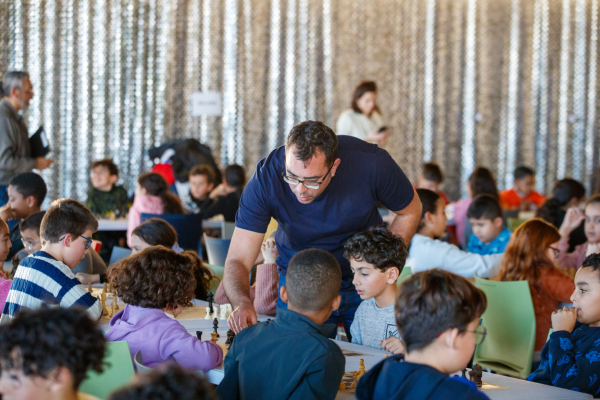 adulte qui aide les enfants aux jeux d'échecs