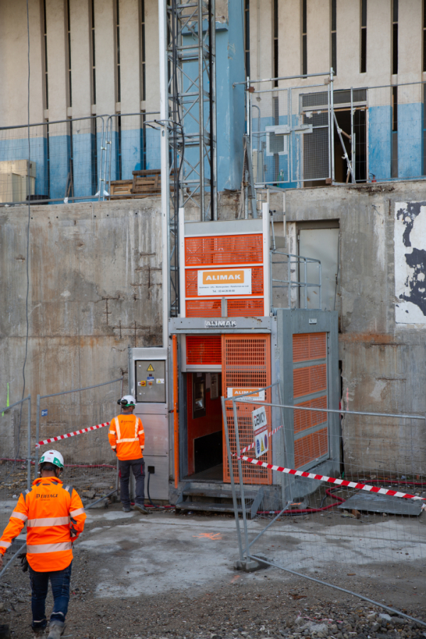 ouvriers à côté de l'ascenseur spécial du chantier
