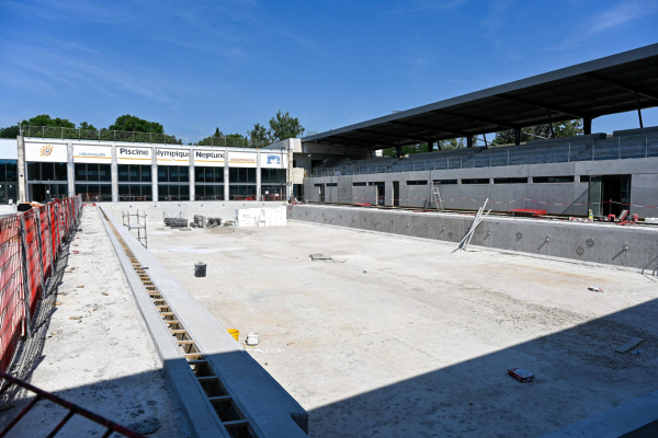 bassin extérieur de 25 m en cours de réhabilitation, nouveaux gradins, bâtiment, ciel bleu