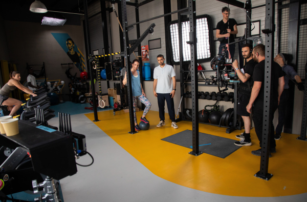 salle de sport appareils de musculation comédiens caméras
