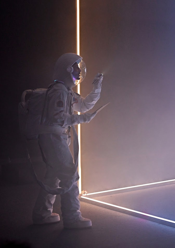 comédien habillé en cosmonaute sur scène jeux de lumière