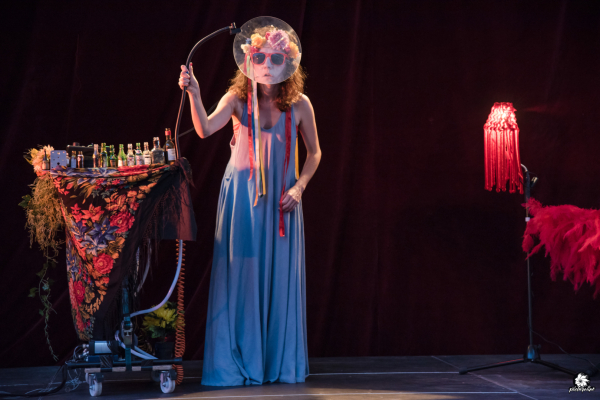 actrice costumée avec nombreux accessoires sur scène 