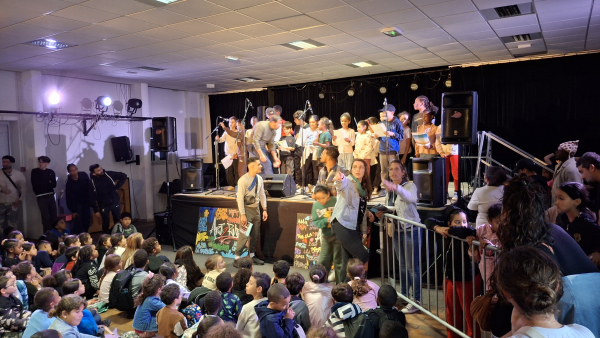 enfants assis animateurs enfants sur scène spolights micros hauts parleurs 