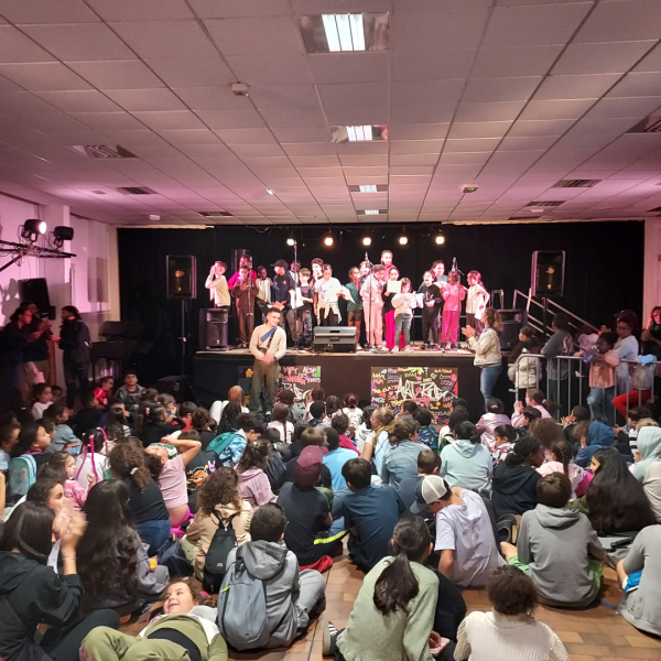 public enfants assis scène enfants micros spotlights animateurs 