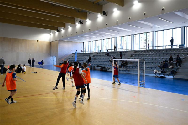 enfants jouant au handball, buts amovibles, gradins, fênetres 