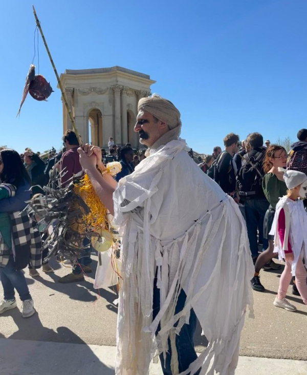 Bonhomme en costume blanc tenant une canne à pêche