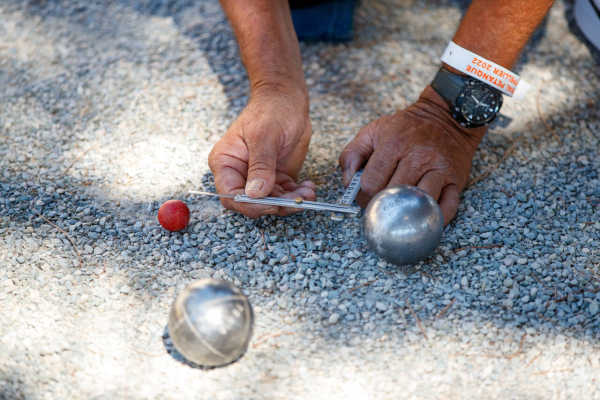 Joueur mesurant l'écart entre boule et cochonnet