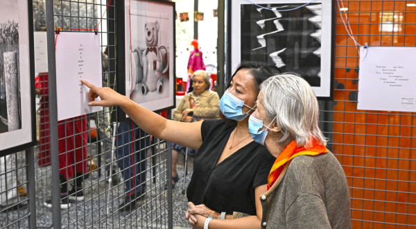 Deux personnes regardent l'exposition photo à l'EHPAD Gauffier