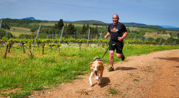 Un homme court avec son chien